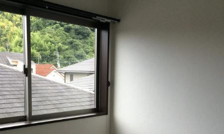 3階の窓から見る隣家の屋根の画像